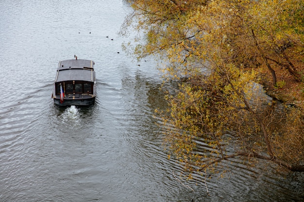 Barca di legno scura che va con il flusso del fiume