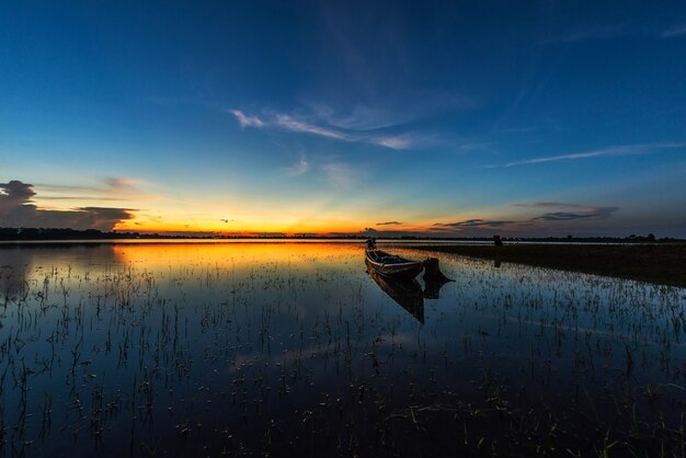 Barca di pesca sul lago con sfondo tramonto