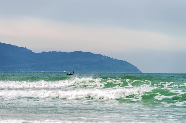 Barca in mare vicino alla China Beach a Danang in Vietnam. Si chiama anche Spiaggia di Non Nuoc. Sullo sfondo il Mar Cinese Meridionale e le montagne di marmo.