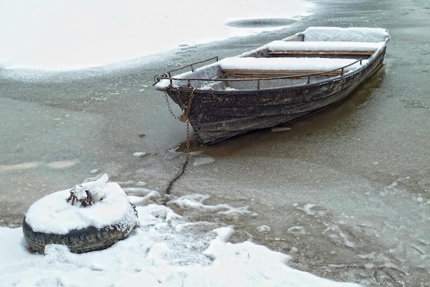 Barca sul fiume ghiacciato coperto di neve