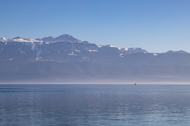 Barca sul vago e nebbioso Lago di Ginevra e sulle Alpi viste da Losanna, Svizzera