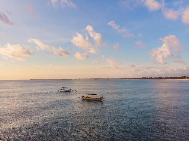 Barca tradizionale balinese Jukung sulla spiaggia di Jimbaran al tramonto a Bali, Indonesia Foto dal drone