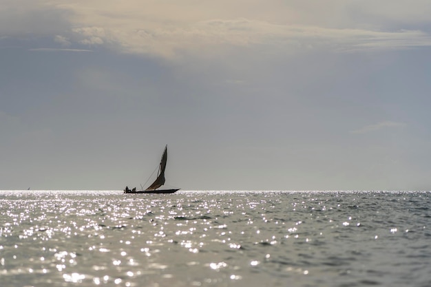 Barca tradizionale di sambuco del pescatore durante il tramonto sull'Oceano Indiano nell'isola di Zanzibar, Tanzania, Africa orientale