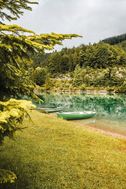 barca vicino alla costa sul lago nelle alpi bavaresi paesaggio con riflesso in acque calme nelle montagne