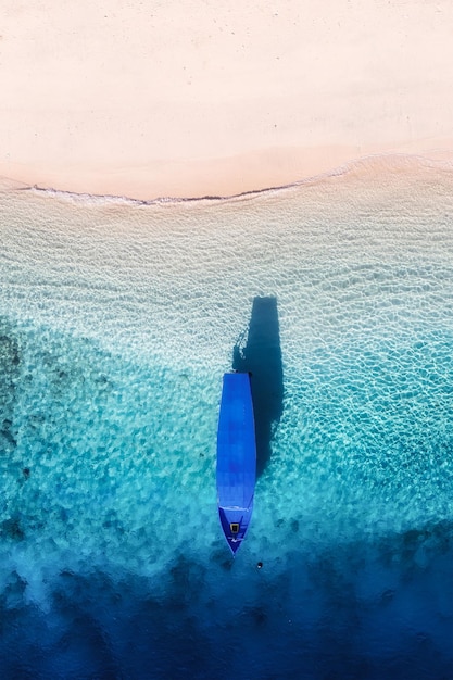 Barca vicino alla spiaggia Paesaggio marino dal drone Sfondo blu acqua dalla vista dall'alto Isola di Gili Meno Indonesia Immagine di viaggio