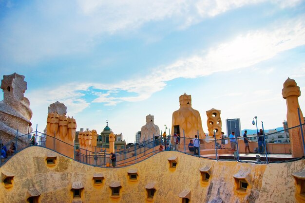 Barcellona, Spagna - 14 agosto 2011: Tetto, camini e turisti all'edificio Casa Mila a Barcellona in Spagna. Chiamata anche La Pedrera, o Miracle Home, o La Cava. Progettato da Antoni Gaudi