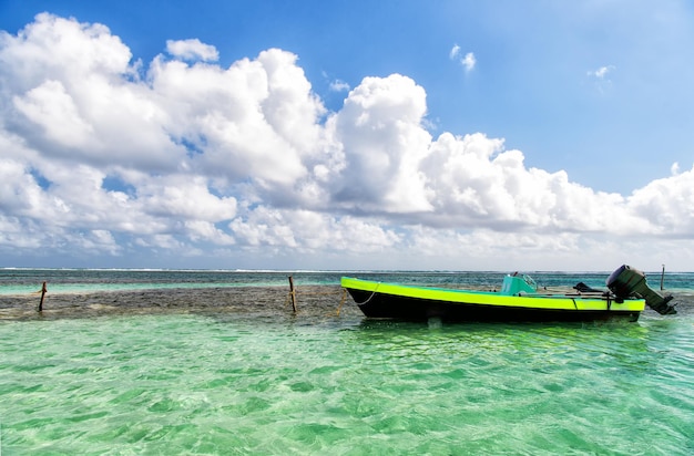 Barche a motore nell'acqua blu trasparente del mare o dell'oceano presso la località turistica tropicale di s in una soleggiata giornata estiva con cielo nuvoloso