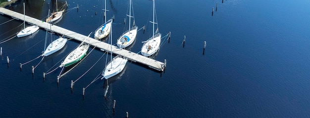 Barche a vela sul molo sulla vista aerea del lago