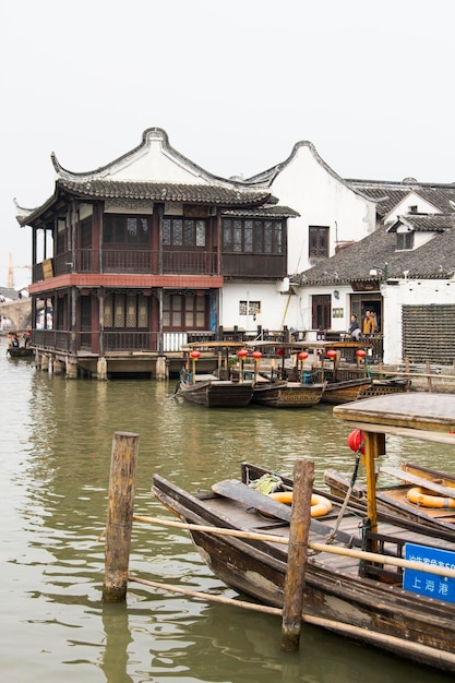 Barche cinesi di legno con lanterne rosse parcheggiate in uno dei canali dell'antica Zhujiajiao