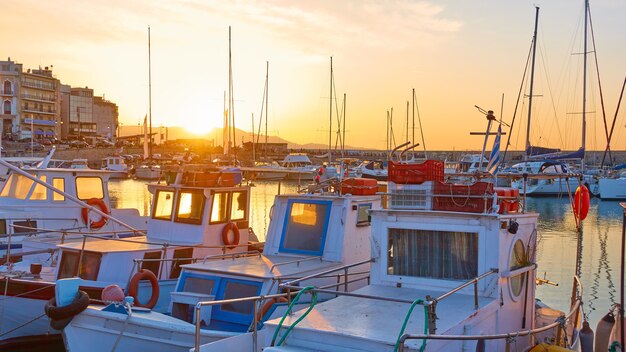 Barche da pesca nel porto di Heraklion al tramonto, Creta, Grecia. Pittoresco scenario greco