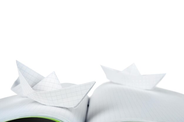 Barche di origami sul taccuino su priorità bassa bianca
