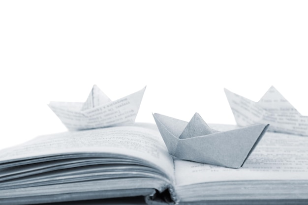 Barche di origami sul vecchio libro su priorità bassa bianca