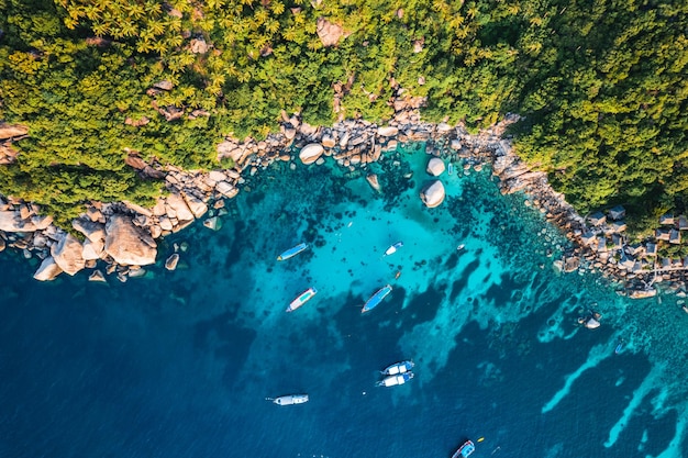 Barche e acque cristalline nel sito di immersione della baia nella barca del tour di Koh Taodiving