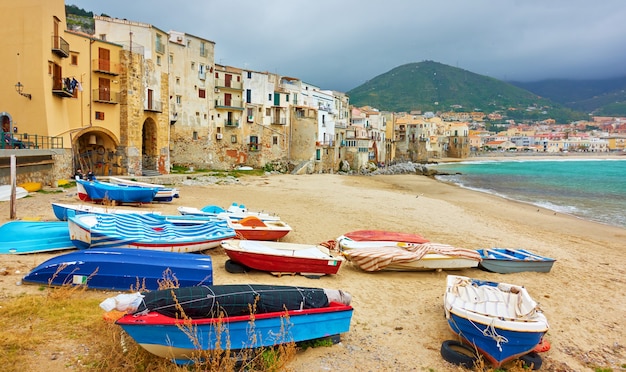 Barche e vecchie case colorate in riva al mare nel centro storico di Cefalù in Sicilia, Italy