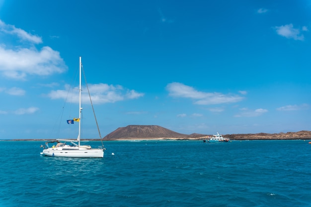 Barche in acque turchesi su Isla de Lobos, al largo della costa nord di Fuerteventura, Isole Canarie. Spagna