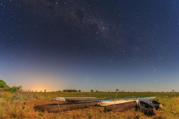 Barche mokoro locali del Botswana sotto il cielo stellato sulla riva del delta del fiume Okavango Botswana