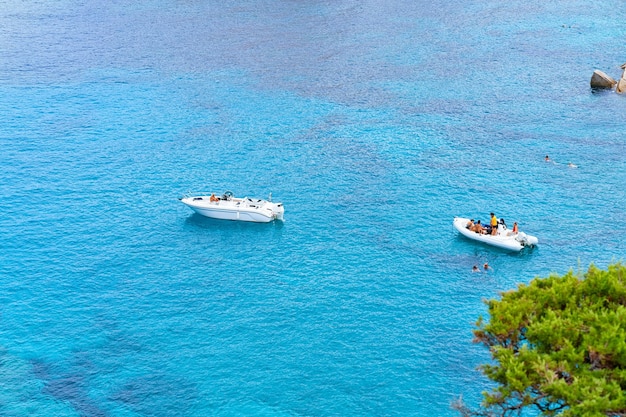 Barche nel Mar Mediterraneo a Capo Testa a Santa Teresa Gallura, Sardegna, Italia. Nave e acqua blu.