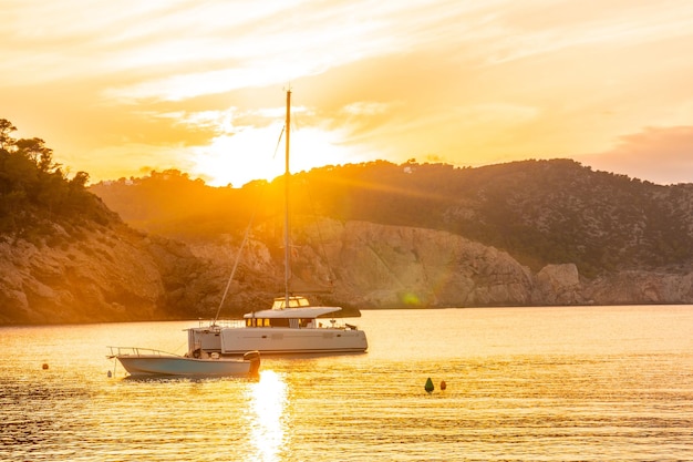 Barche sulla spiaggia al tramonto a Benirras nel concetto di vacanza di Ibiza