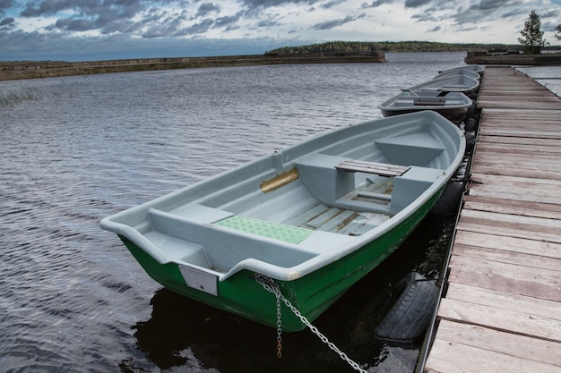 Barche vuote sul lago lungo il molo in legno