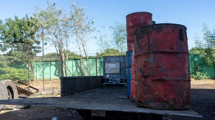 Barili con olio per il riciclaggio caricati su un camion