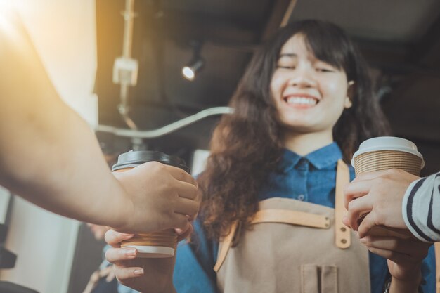 Barista che dà il caffè al cliente nel suo negozio