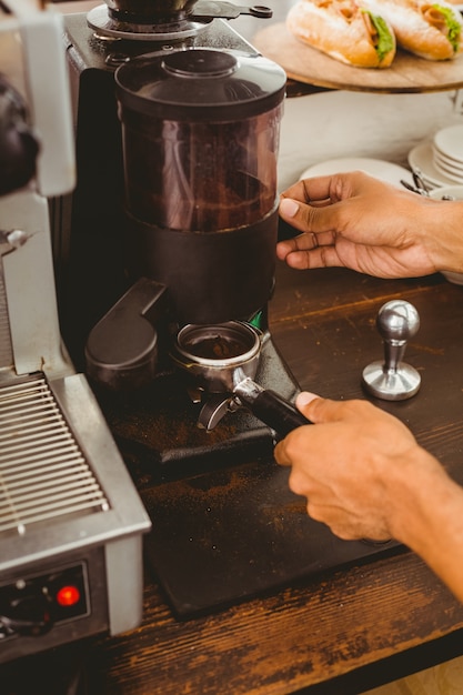 Barista che macina i chicchi di caffè freschi