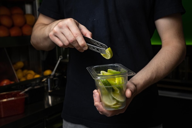 barista che prepara cocktail con limone e menta