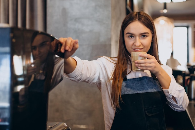 Barista che prepara il latte in una caffetteria