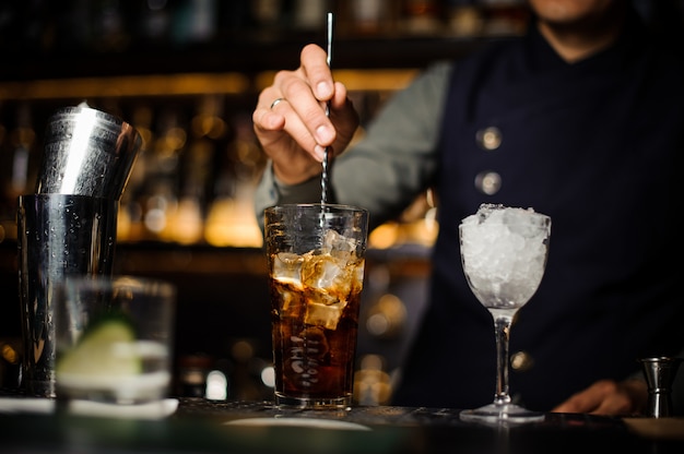 Barista che prepara un cocktail fresco in un bicchiere