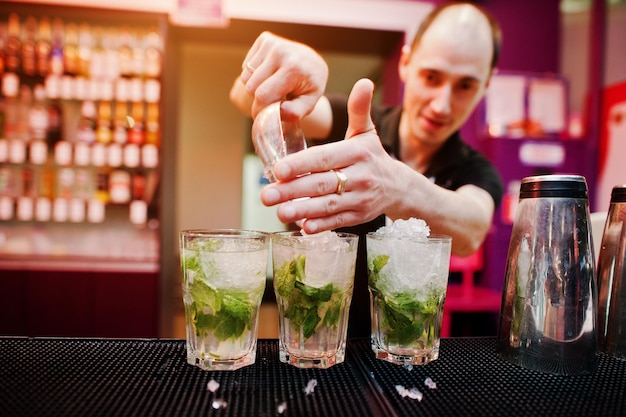 Barista che prepara un cocktail mojito al bar