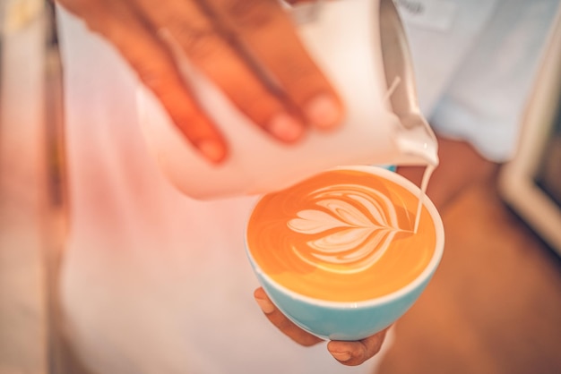 Barista che prepara una tazza di caffè latte art Vista in primo piano della tazza di bevanda mattutina Idilliaca mattina felice