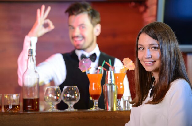Barista che serve cocktail per donna attraente.