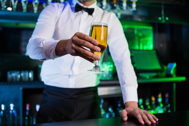 Barista che serve un bicchiere di birra al bar