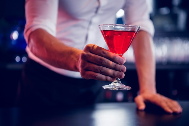 Barista che serve un martini rosso nel bar