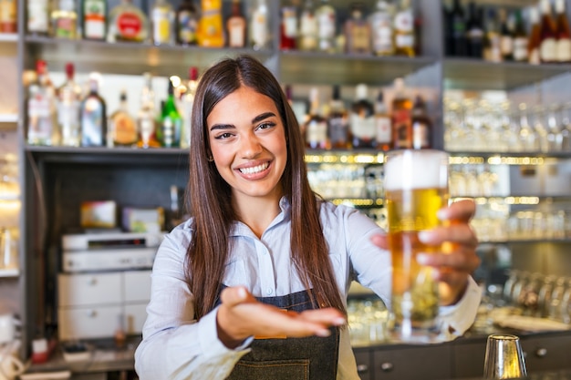 Barista che serve una birra alla spina al bancone del bar