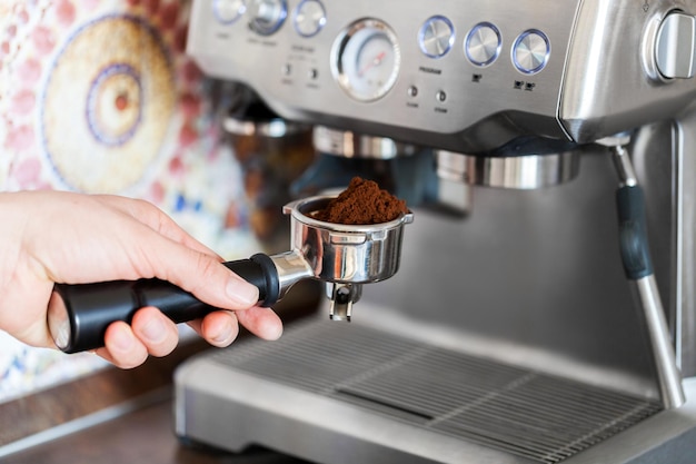 Barista che tiene caffè macinato per preparare l'espresso