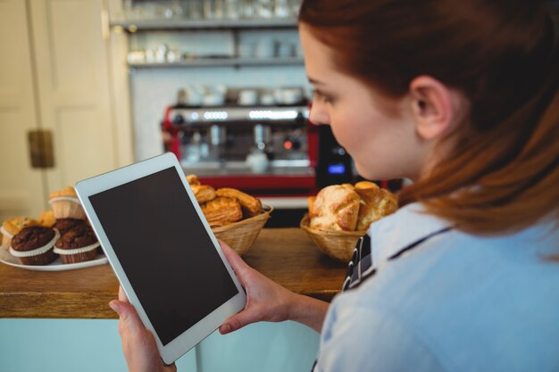 Barista che utilizza computer tablet al caffè