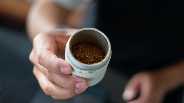 Barista che versa il caffè dalla caffettiera moka a una tazza di caffè Mano che tiene il caffè versando la caffettiera moka classica italiana