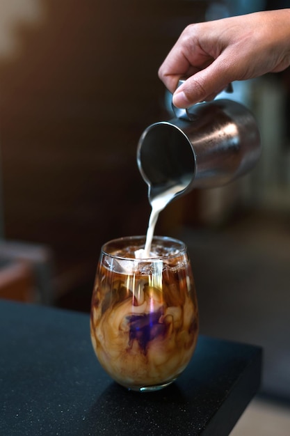 Barista che versa il latte nel bicchiere