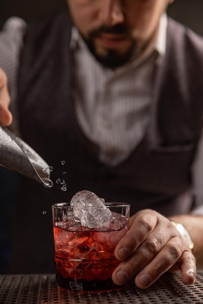 Barista che versa un cocktail al bar