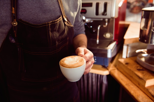 Barista del Latte del caffè che fa modello in una tazza di caffetteria.