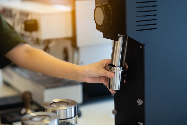 Barista delle donne che fa il caffè in una macchina da caffè, concetto di preparazione del caffè