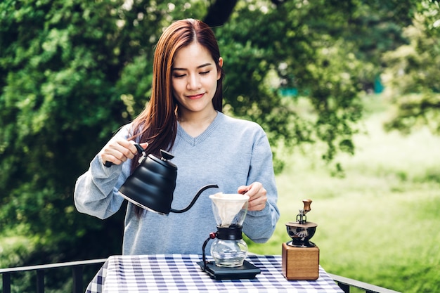 Barista delle donne che produce caffè americano nel parco