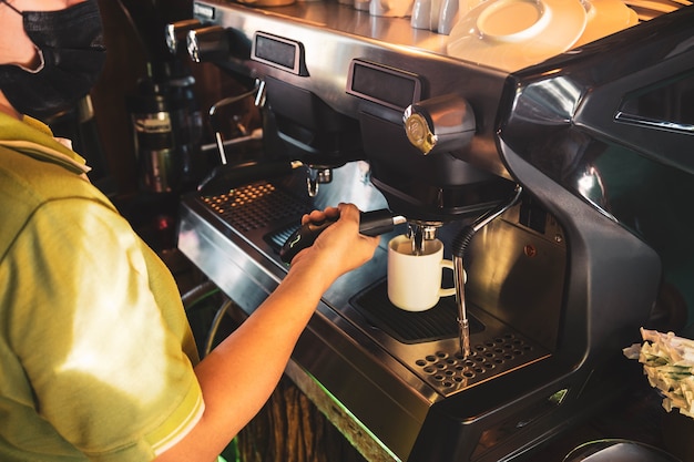 Barista, donna asiatica Preparazione del caffè con una macchina per il caffè.