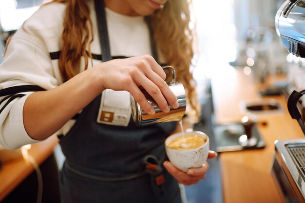 Barista femminile che fa il caffè in una macchina da caffè Concezione di affari e servizio Cibo da asporto