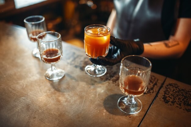 Barista femminile che tiene un bicchiere con cocktail