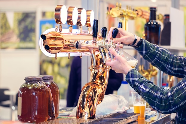 Barista mano al rubinetto della birra versando una birra alla spina in vetro che serve in un ristorante o pub