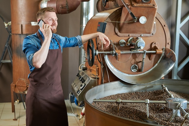 Barista moderno che parla al telefono