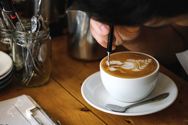 Barista professionista che fa bella arte del latte