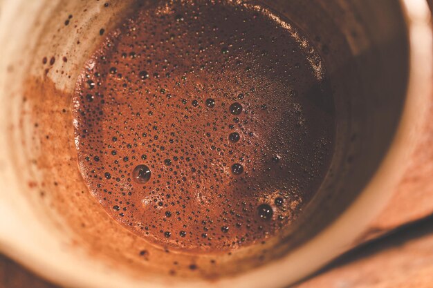 Barista professionista che produce bevanda al cioccolato da polvere di cacao scuro in tazza marrone con latte caldo con aroma dolce in tazza su sfondo vintage cafe la colazione del mattino